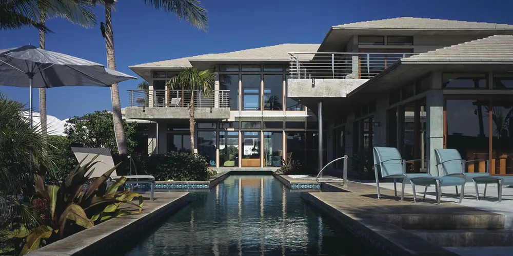 Featuring a sophisticated blend of sleek lines and organic textures, the exterior showcases expansive glass windows and an inviting pool framed by lush greenery. The interplay of natural light and open space creates a harmonious indoor-outdoor experience, embodying luxurious minimalist living. Ideal for those seeking a seamless fusion of aesthetic appeal and functional design.