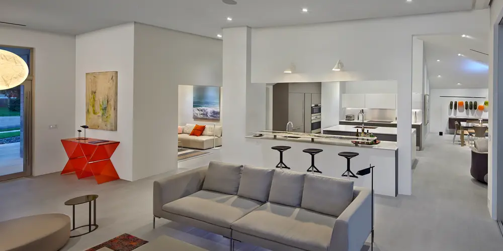 This view of the open concept kitchen within the living space underscores the seamless integration and multifaceted design approach of the home. The kitchen serves as a pivotal area fostering interaction and practicality, characterized by its sleek cabinetry and efficient layout. The visibility to other areas of the home, such as the dining space and entryway, enhances the fluidity and connectivity, embodying a modern lifestyle that values openness and accessibility.