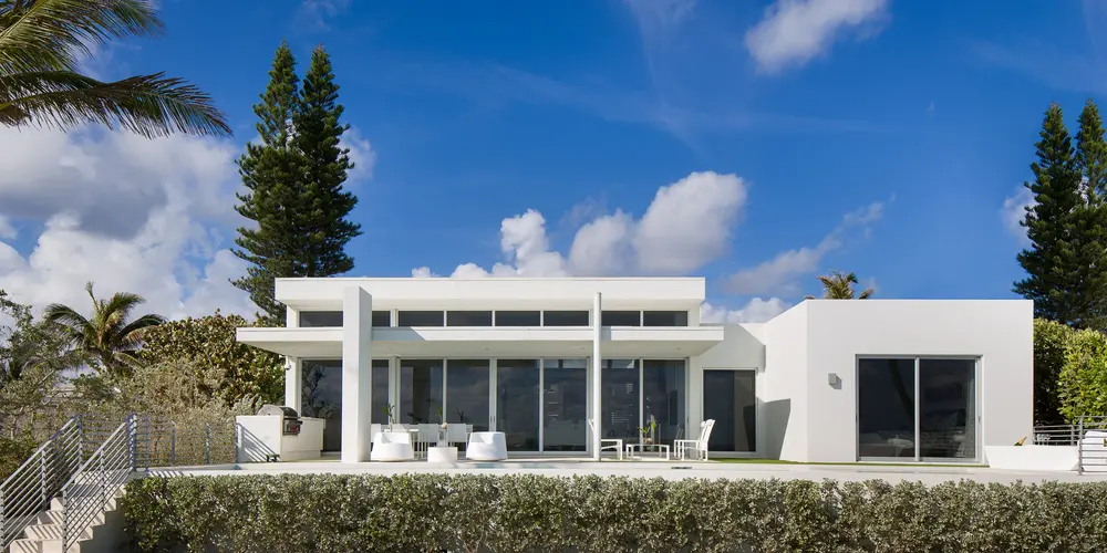 The rear of the home emphasizes the expansive terrace with open views and plush areas for relaxation. Large glass doors blur the boundaries between the interior and exterior, ideal for entertaining.