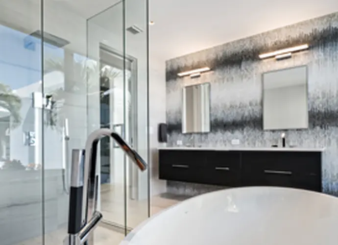 Featuring a luxurious soaking tub and dual vanities, this bathroom is designed for relaxation and functionality. The sleek textures and contrasting monochrome palette create an elegant, stress-free environment.
