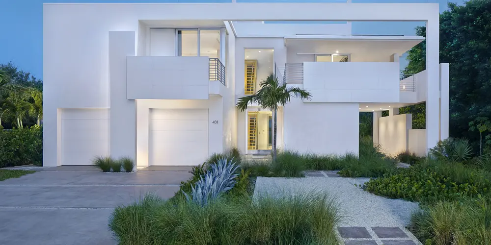 The home's facade presents a striking modern design with clean lines, geometric balance, and natural integration that exudes sophistication.