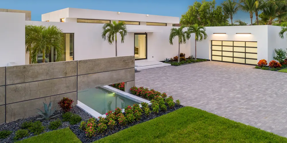 The geometric landscaping, highlighted by palm trees and a reflecting pool, adds elegance and tranquility, enhancing the property's visual appeal.
