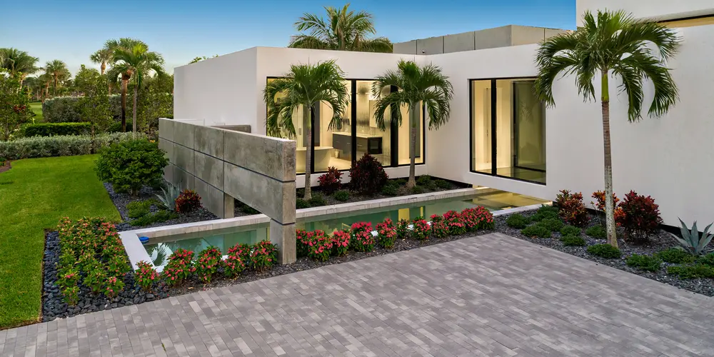 
Design Details: The entrance is framed by tropical foliage and a reflective water feature that leads the eye toward the sleek architecture of the house, enhancing its allure and inviting ambiance.
Summary: The entrance combines modern elegance with a welcoming natural touch, setting the tone for the rest of the luxurious property.