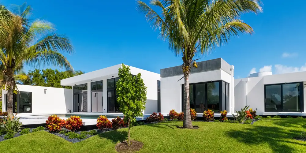 This view captures the essence of modern architecture through clean lines and expansive windows, beautifully integrated with lush, vibrant landscapes to create a serene and elegant outdoor living area.