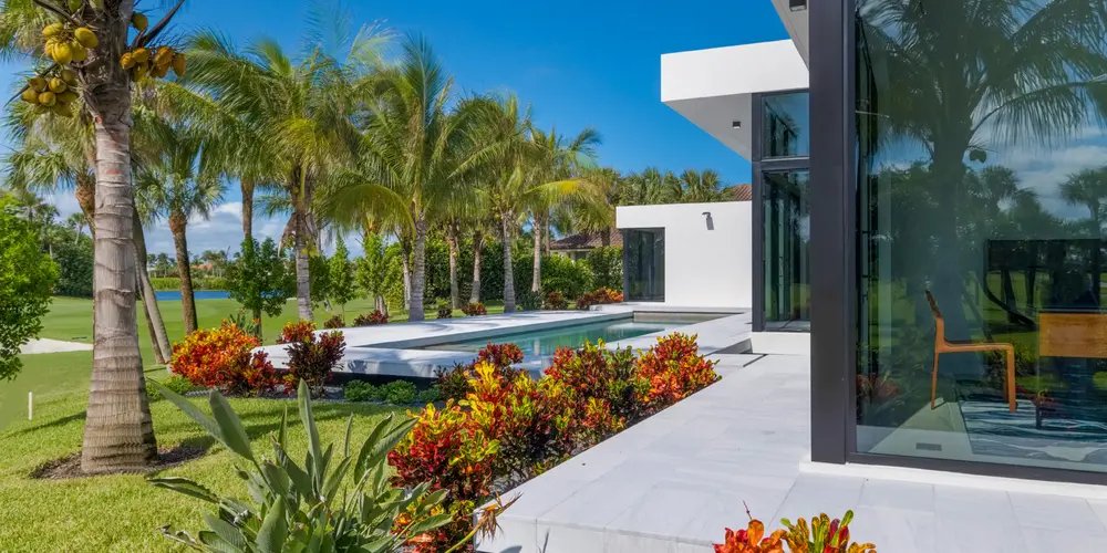 This backyard features a striking integration of a contemporary pool with lush tropical surroundings, providing a balanced retreat of luxury and relaxation.